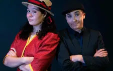 actress in red shirt and straw hat leaning against actor in black suit