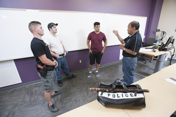 instructor talking with three male students