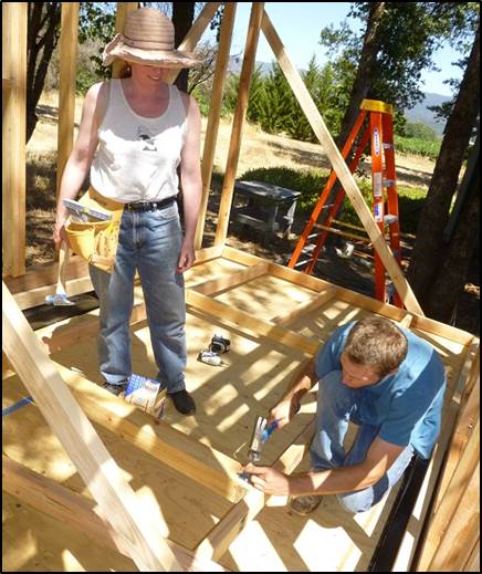 two students work to frame a house
