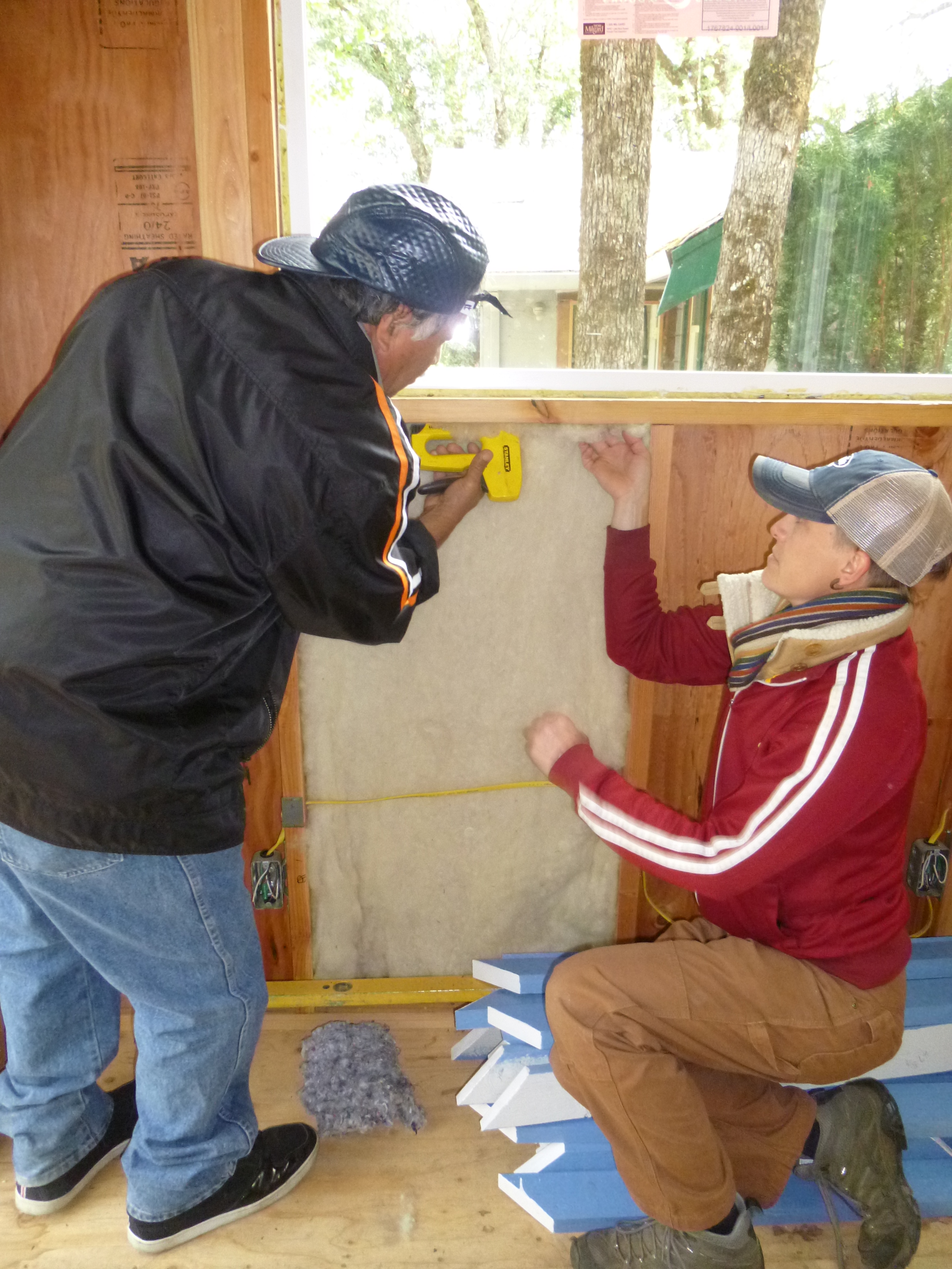 two students install insulation