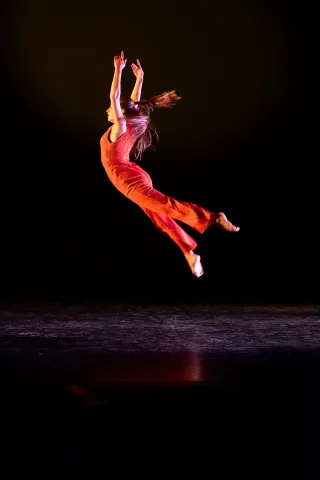 Dancer leaping gracefully over the stage